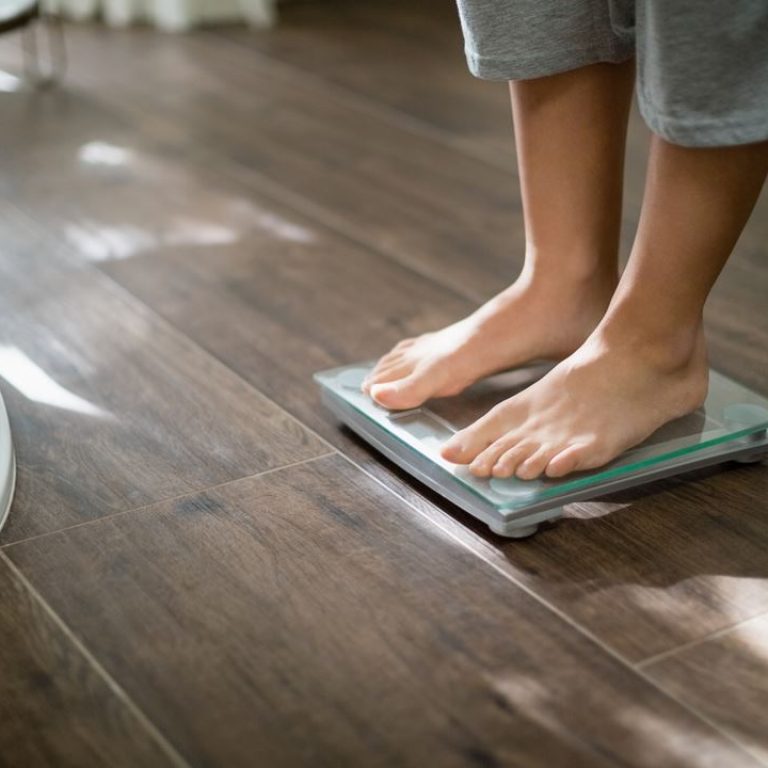 boy-checking-his-weight-on-weight-scale-FHMQAD9