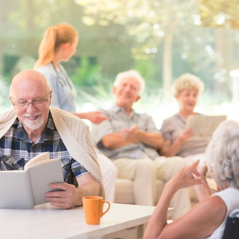 smiling-senior-man-reading-book-PTADECQ